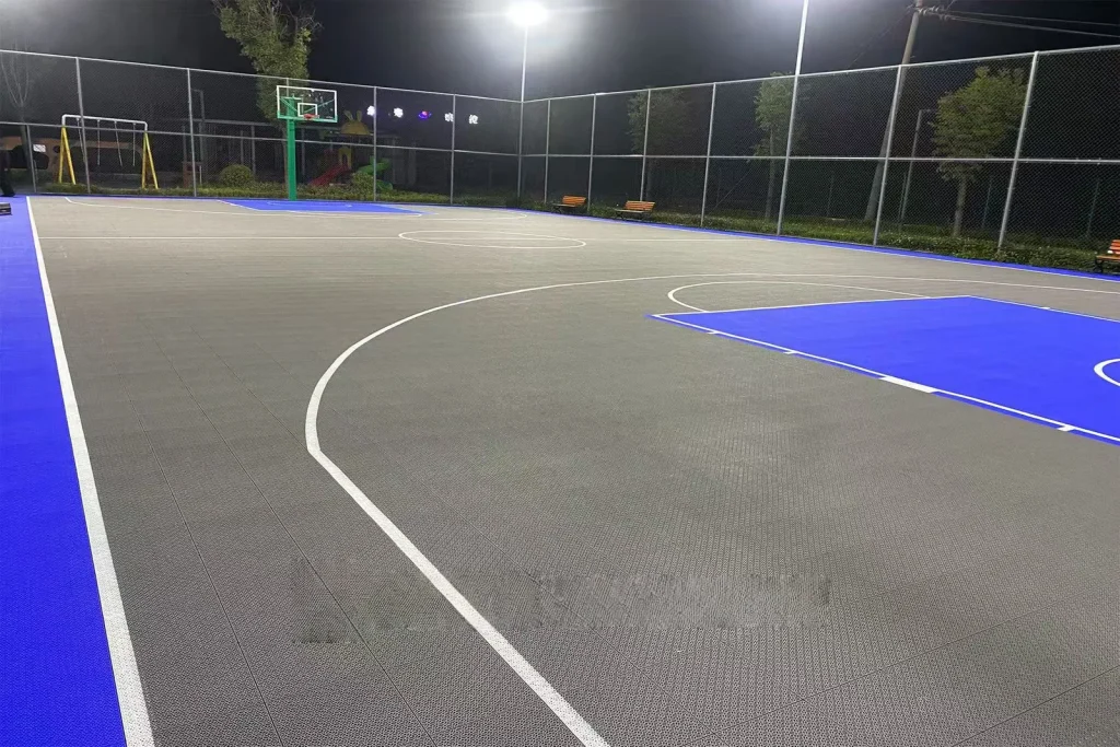 Basketball surface and court lines under evening lights