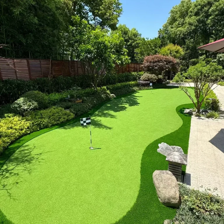 Landscaped artificial grass putting area beside a garden path
