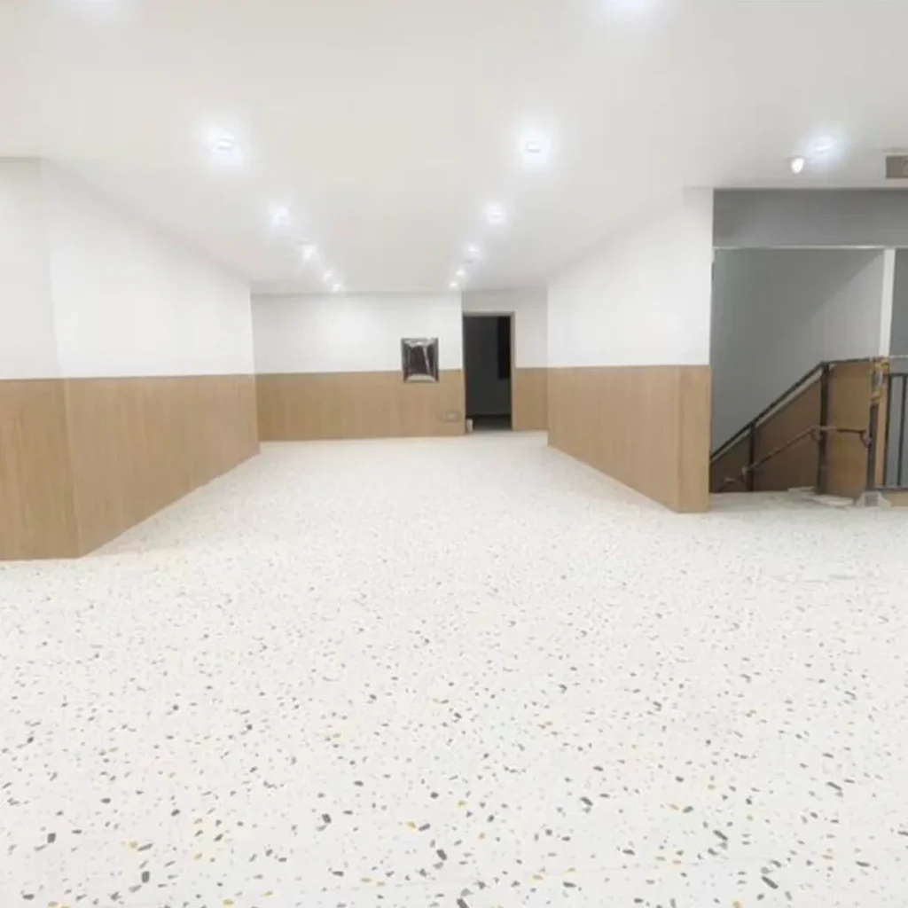 Bright indoor activity room with a speckled floor