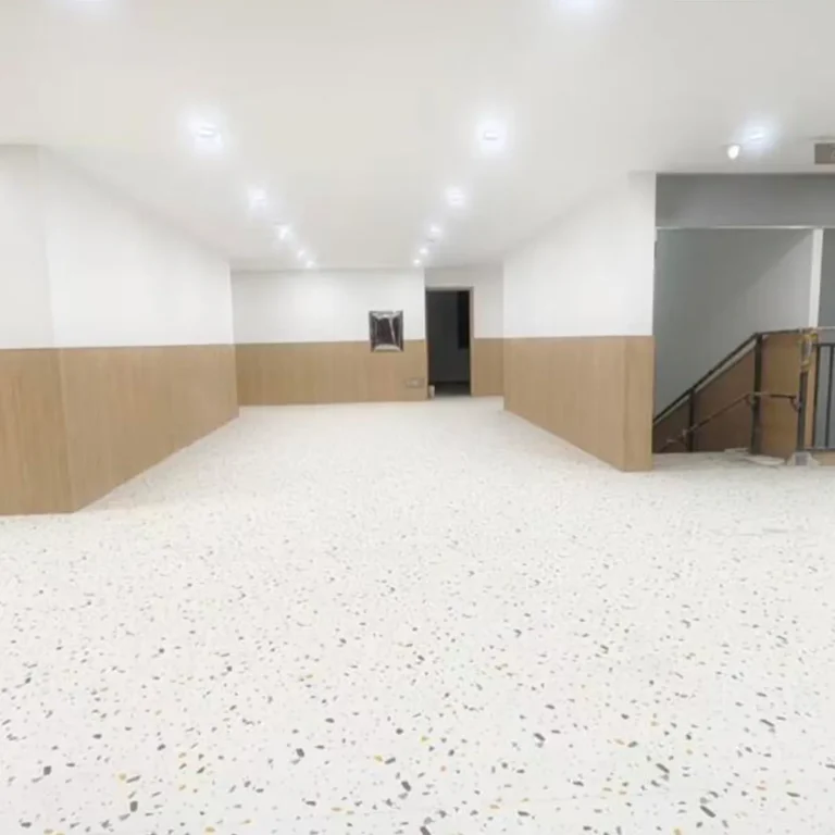 Bright indoor activity room with a speckled floor