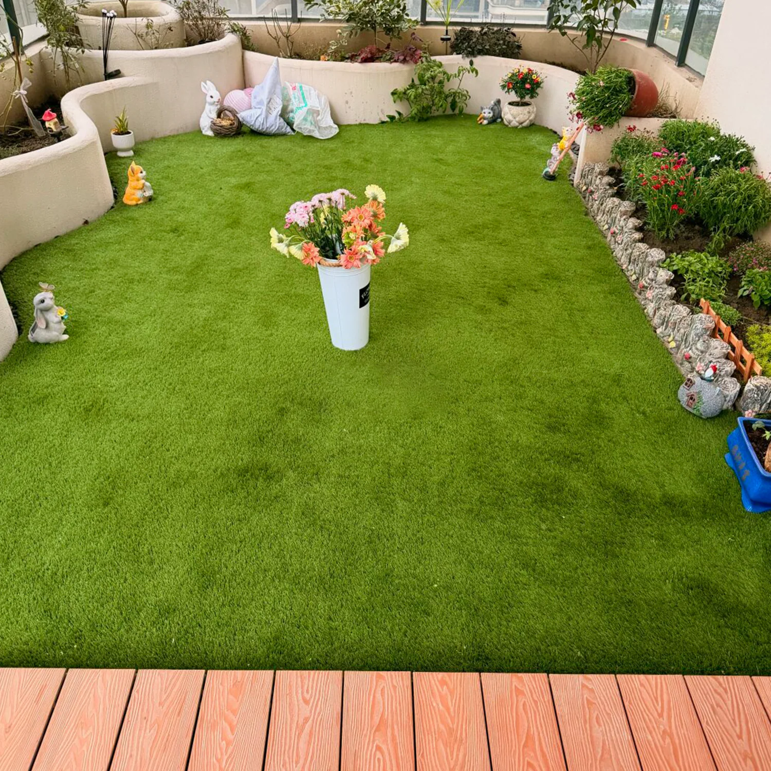 Artificial grass courtyard bordered by planting and decking