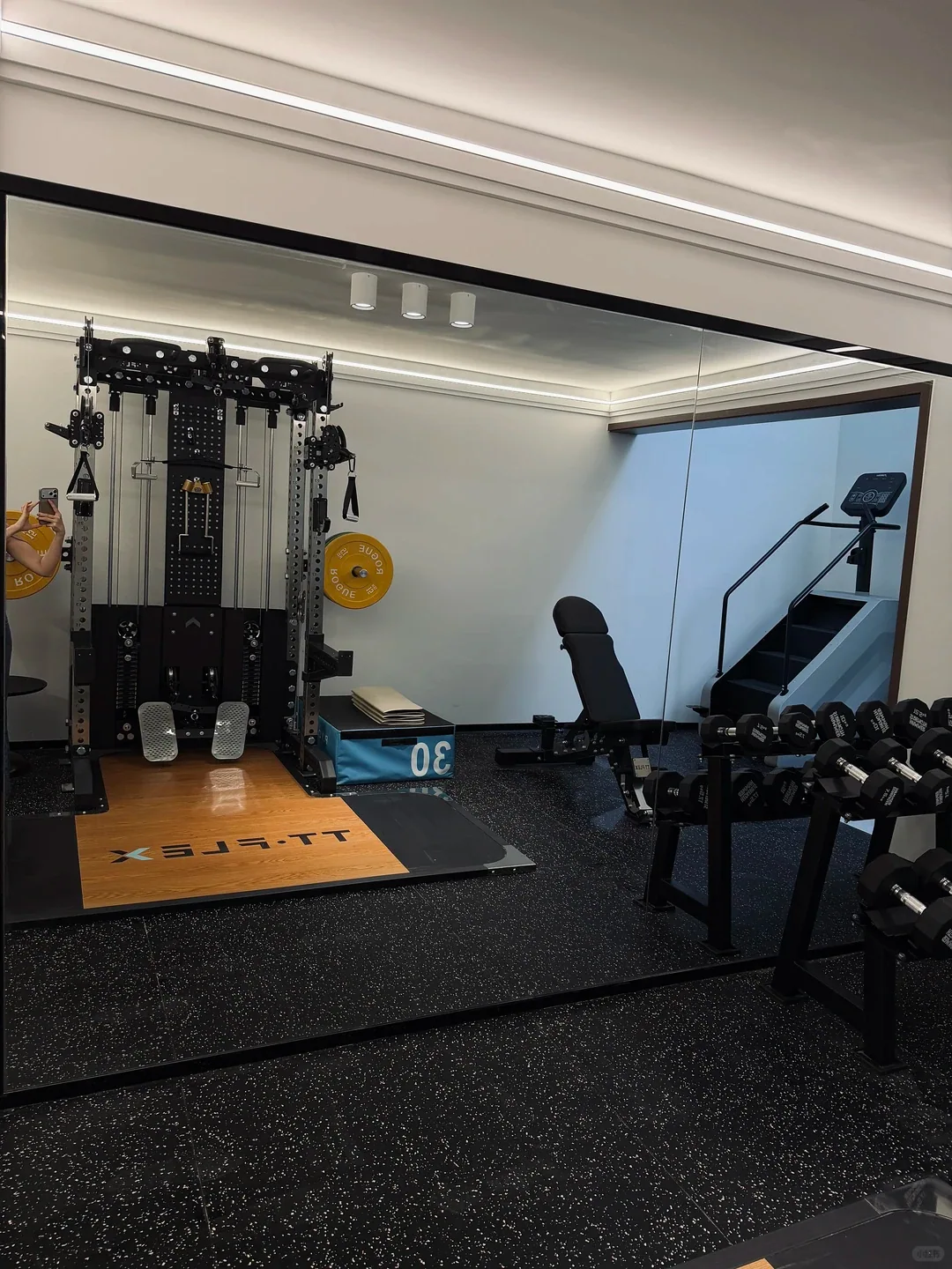 Weight-training room with black rubber floor tiles and a lifting platform