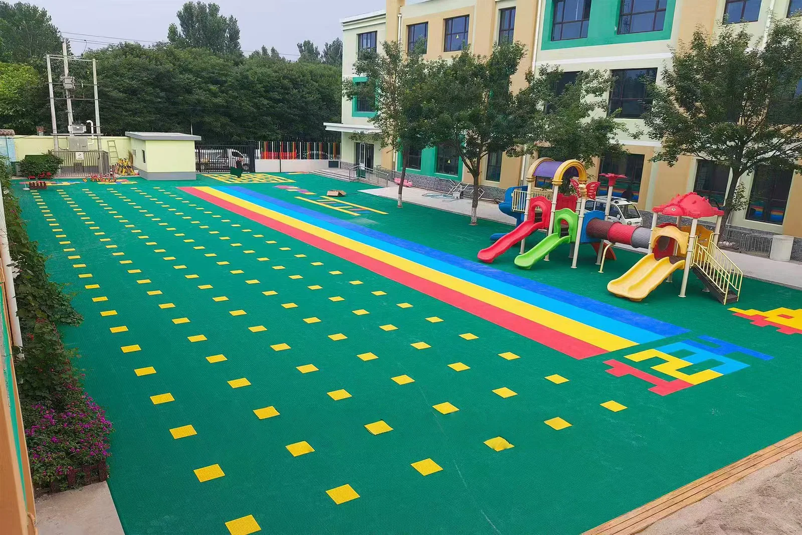 Colourful outdoor activity surface beside school play equipment